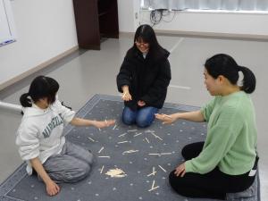 鹿児島では人気といわれる、「キイゴ」という遊びを体験している3人
